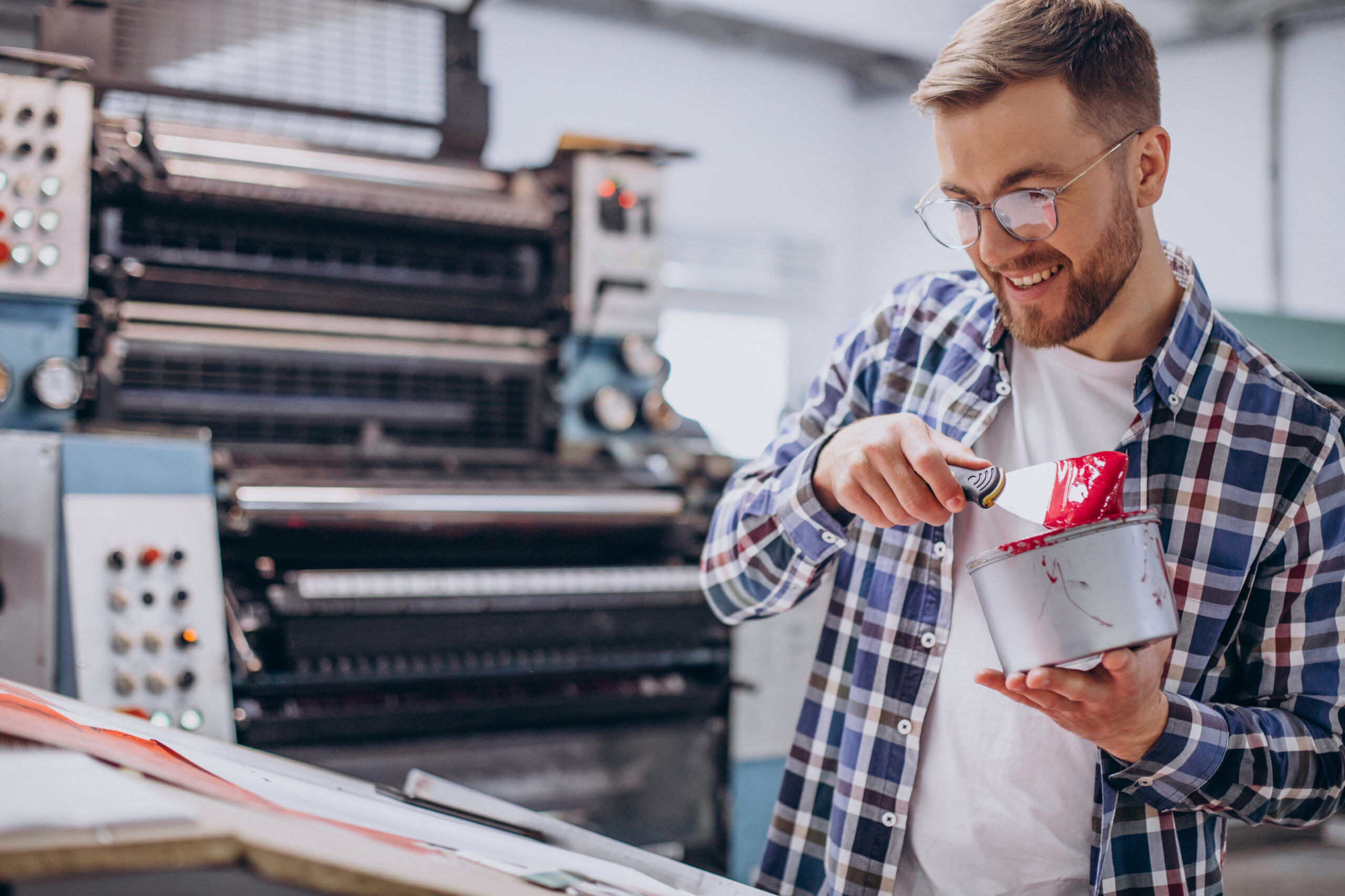 Man working in printing house with paper and paints